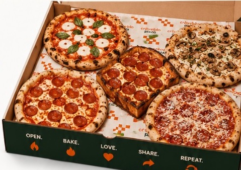 A box filled with assorted artisan pizzas from across America